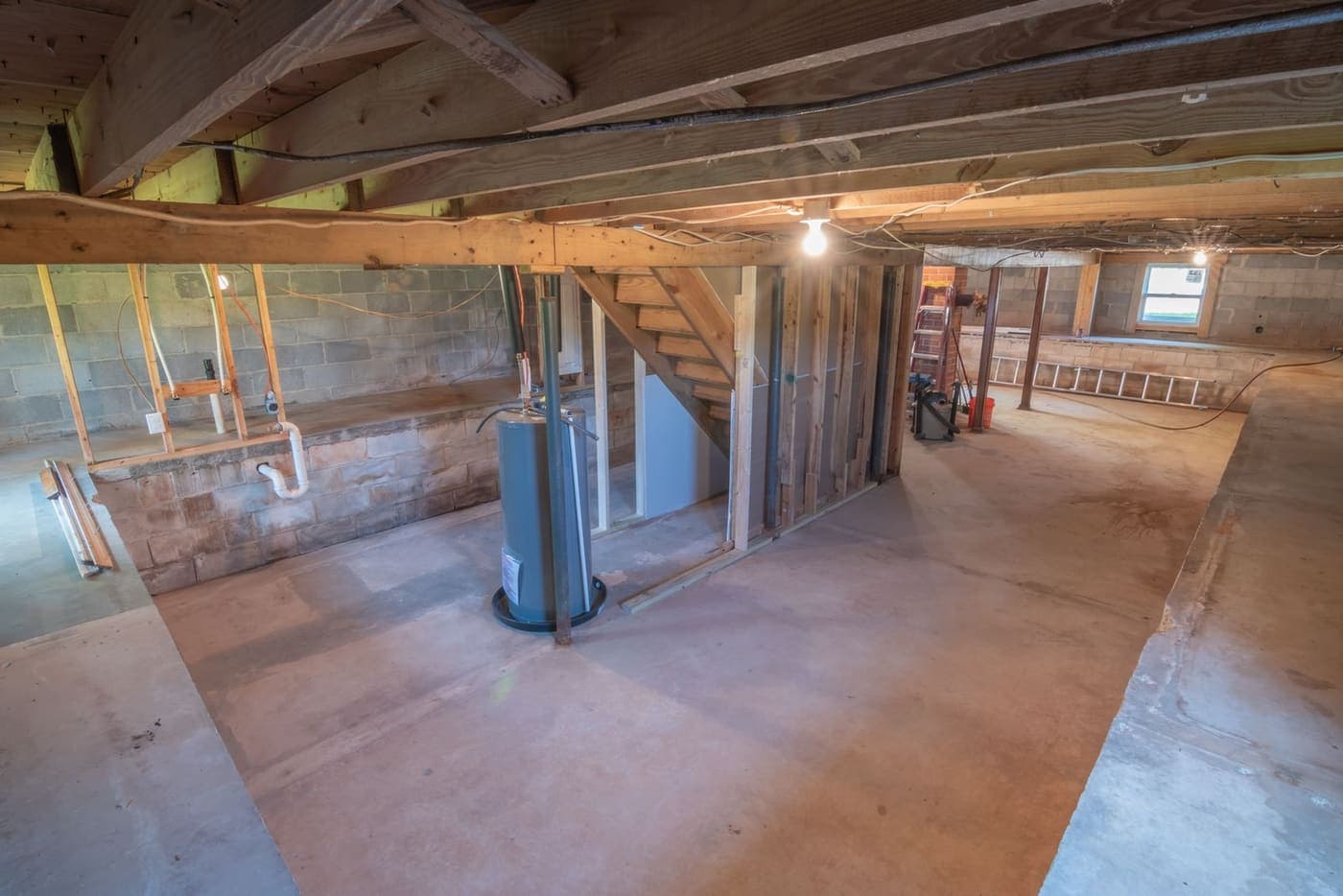 Unfinished basement with block foundation walls showing moisture staining