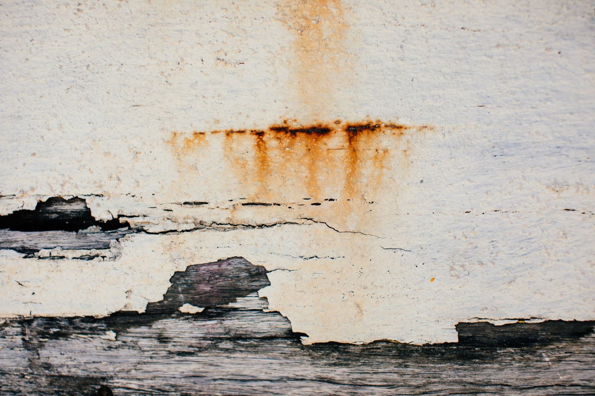 Rust-colored water stains bleeding through a ceiling surface
