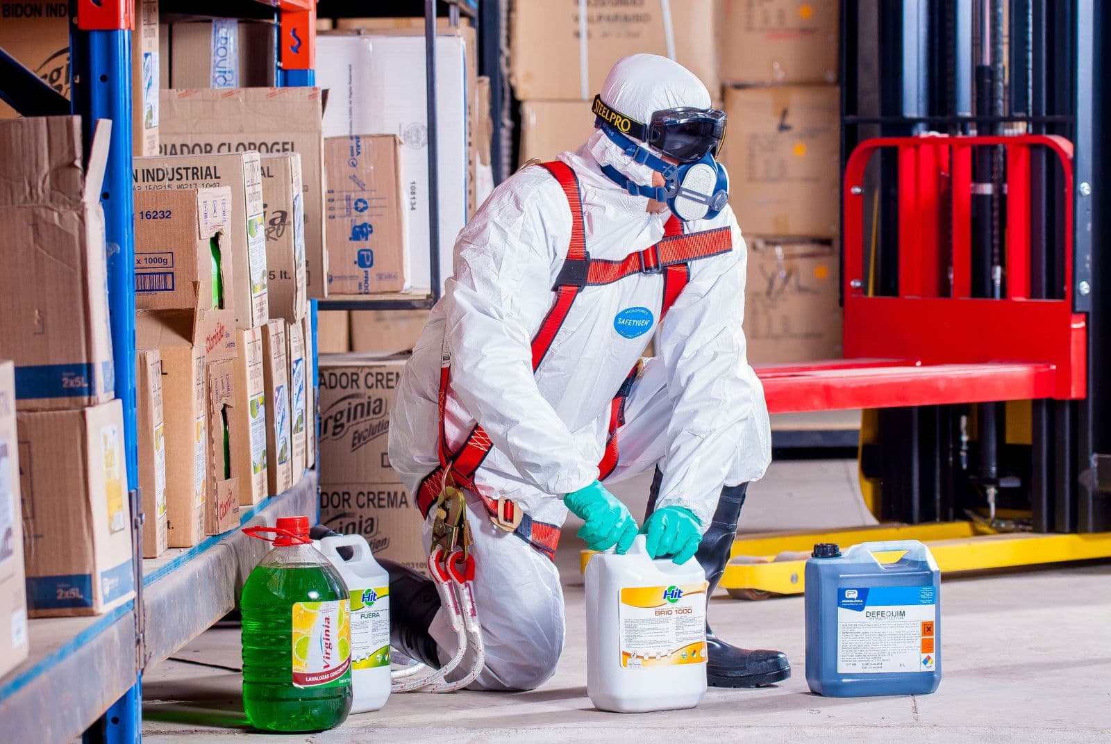 Mitigation worker in full protective suit and respirator handling treatment chemicals