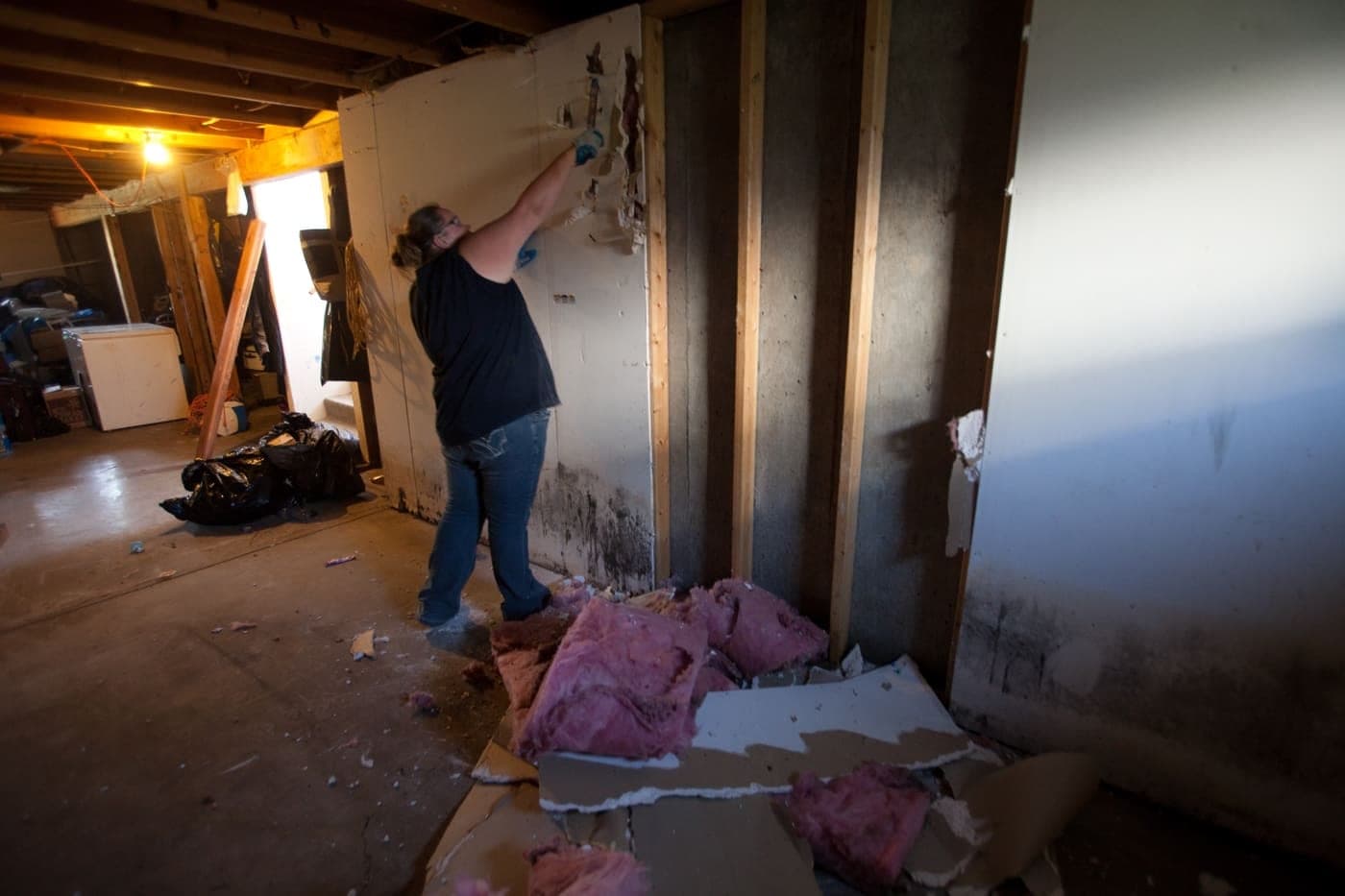 Water-damaged drywall and wet insulation torn out down to the studs