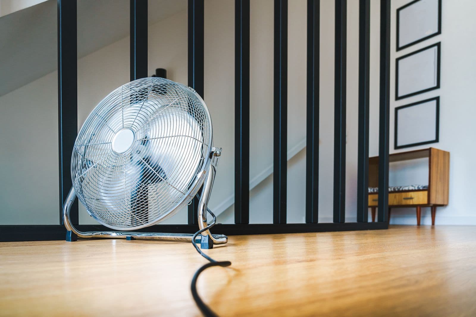 High-airflow fan drying a hardwood floor during water damage restoration