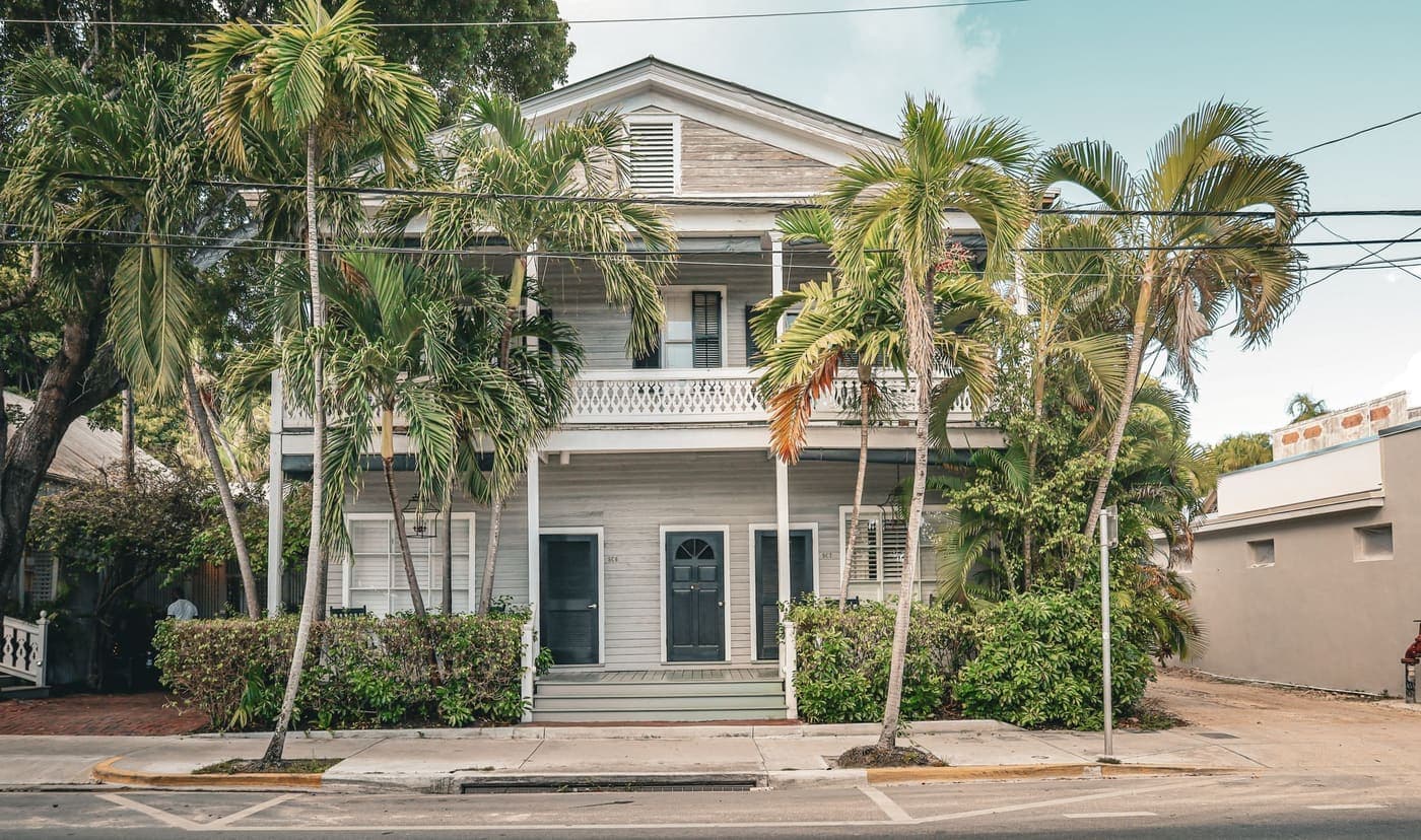 Two-story Key West Florida home surrounded by palm trees