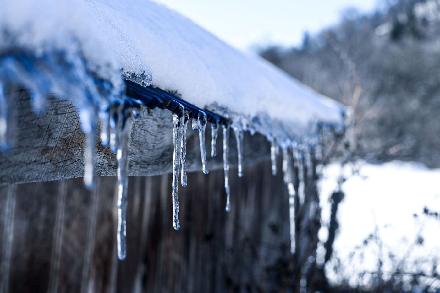Icicles hanging from a snow-covered roof during a hard freeze