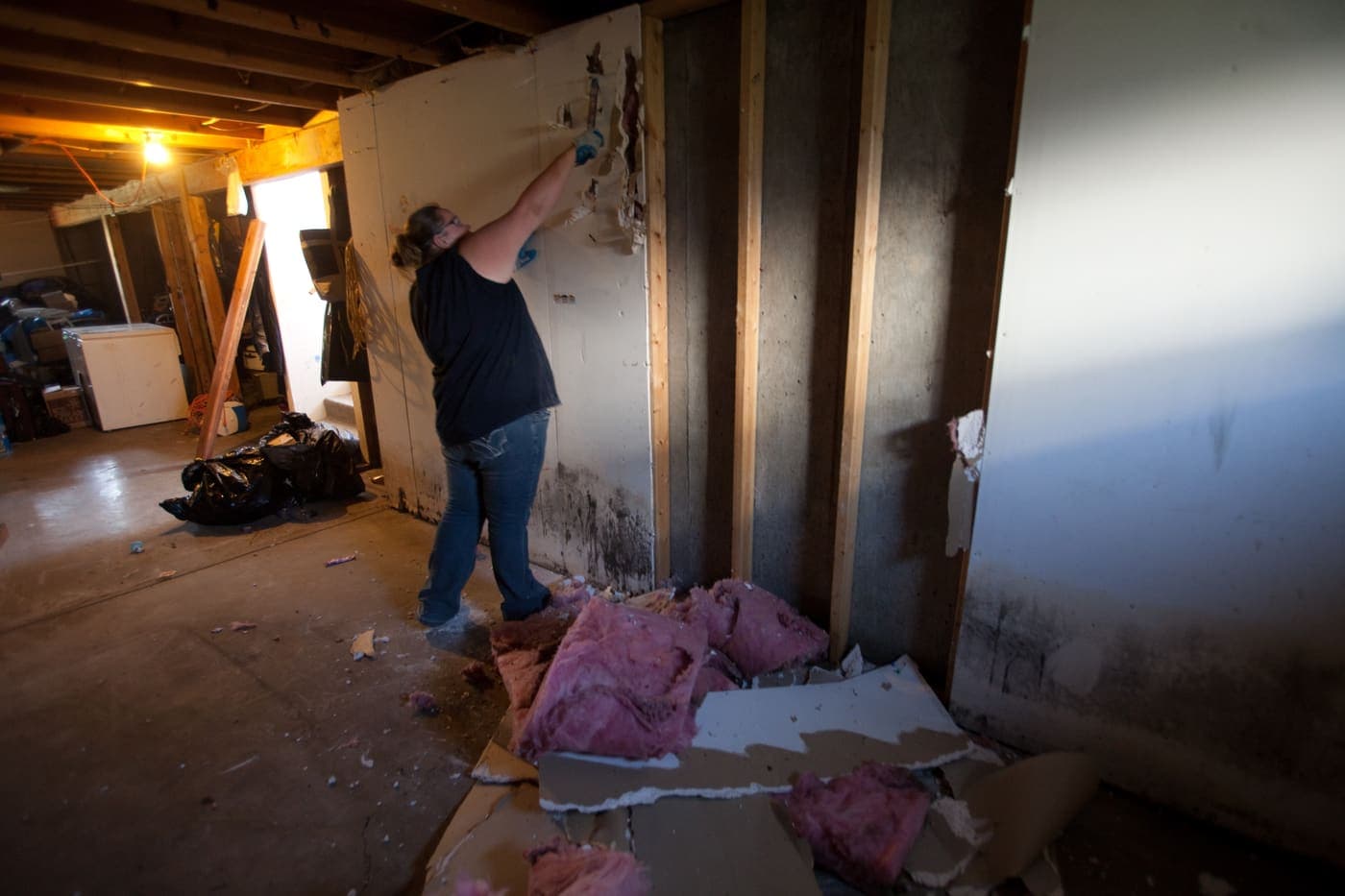 Wet drywall cut out along a flood line, exposing the studs for drying